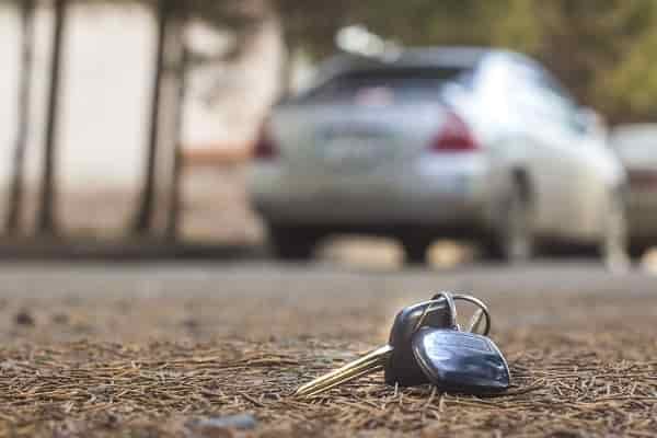 a set of car keys sits forgotten on the ground outside behind a car